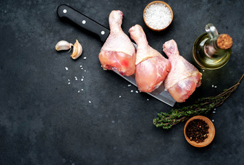 raw chicken legs with spices on a knife with copy space for your text