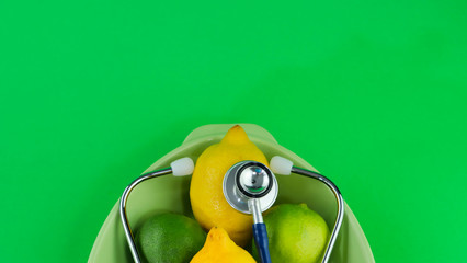 Deux citrons et deux limes sur un arrière plan de couleur vert fluorescent