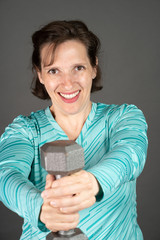 Older woman working out with a dumbbell at home.