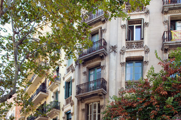Fototapeta na wymiar Close up view of traditional, historical, typical residential building in Barcelona showing Spanish architectural style. Catalan flag is hung at a balcony. t is a sunny summer day.