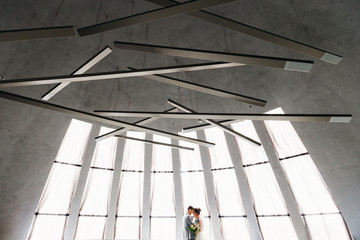 embrace newlyweds in the restaurant hall with large panoramic wi