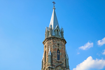 Obraz premium The spire of the old church against the blue sky.