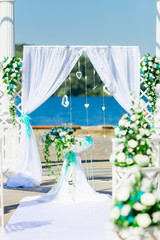 Wedding arch decorated with cloth and flowers. lake shore.