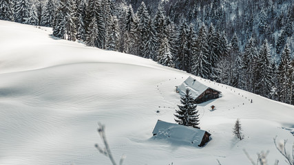 Beautiful winter landscape with deep snow-covered houses at the famous Rossfeldstrasse near Berchtesgaden, Bavaria, Germany