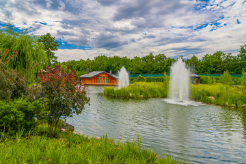 Landscaping. Beautiful pond with fountain in green park at Mezhgorye residence, Ukraine