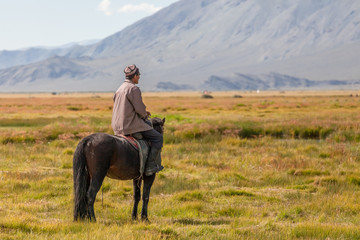Altai, Mongolia - June 14, 2017: Nomad with his faithful horse in the steppes of Mongolia....