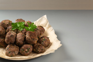Homemade fried meatballs with herbs on a grey background. Swedish traditional cuisine.