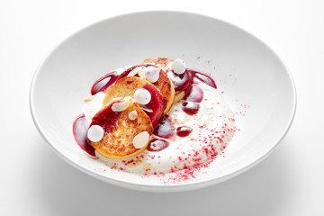 cheese pancakes dessert with berry sauce and cream in bowl isolated on white background