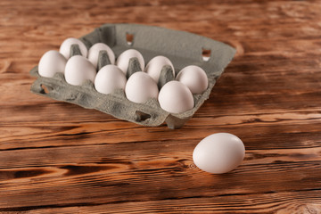 Egg on the background of egg packaging on a wooden table.