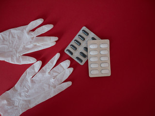 Close up of vitamin pills and white latex glove. One of the ways to reduce the spread of virus....