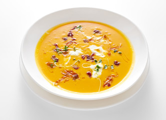 pumpkin soup in bowl isolated on white background