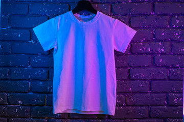 White color unisex t-shirt in neon light , copy space
