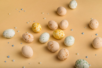 Easter background with beige marzipan eggs on beige background