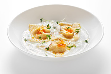 bowl with ravioli with caviar in cream sauce isolated on white background