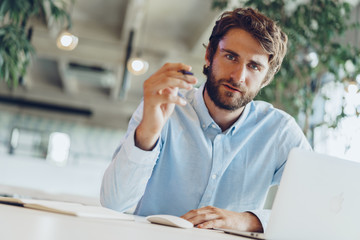 Businessman in shirt working on his laptop in an office. Open space office