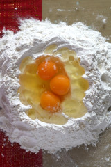 Making pasta dough with flour and eggs. Top view.