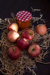 Fresh apples in front of a jar of compote
