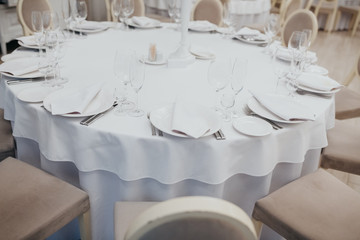 White table with plates knives, forks and napkins.