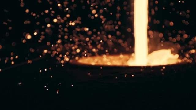 Liquid Metal is pouring out from the foundry. Metal Factory, Cast, Slow motion