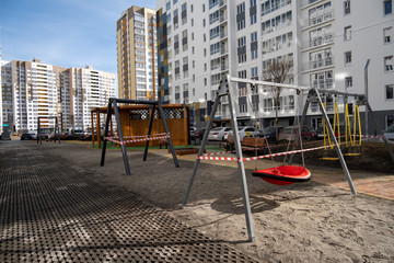 cordoned off swings on a playground in time of coronavirus quarantine - Tyumen, Russia, March 31,...
