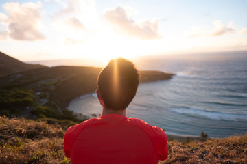 Man looking off to the horizon - future - Hanama Bay sunrise - golden hour - over pacific ocean