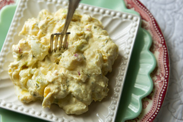 Southern style potato salad on antique plates. 