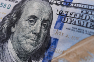 Obraz na płótnie Canvas Benjamin Franklin on a 100 US dollars bill. Concept of recession and worldwide economic crisis.