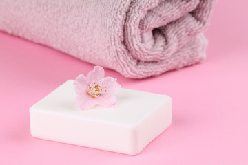 Obraz na płótnie Canvas A towel and peach soap on a pink background. Bodycare.