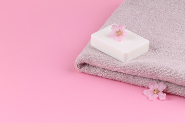Obraz na płótnie Canvas A towel and peach soap on a pink background. Bodycare.