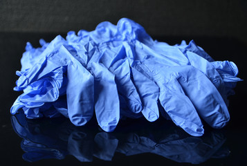 Coronavirus concept.Disposable blue medical latex gloves on black background. Hygiene rules during the coronavirus epidemic.Healthcare equipment concept.