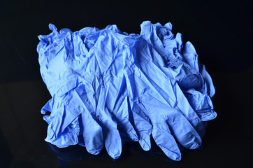 Coronavirus concept.Disposable blue medical latex gloves on black background. Hygiene rules during the coronavirus epidemic.Healthcare equipment concept.
