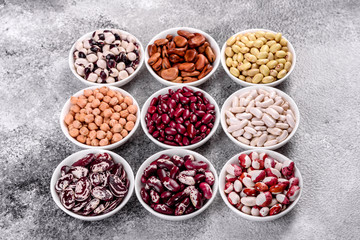 Pulses health food selection in white porcelain dishes over concrete background