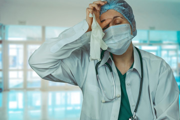 Fototapeta premium overworked female doctor on blurred hospital background emotional portrait