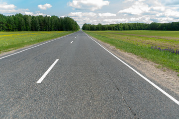 Highway or asphalt road through the forest. An empty roadway with no cars or people. Travel to natural places or reserves. social distance. Absence of people. Coronavirus. COVID19