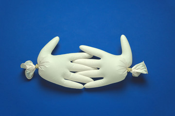 handshake of inflatable rubber gloves on a blue background