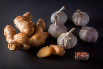 Ginger root and garlic on a wooden background are natural remedies for the virus. Low key