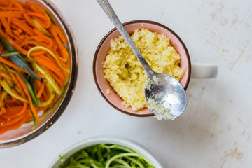Cooked couscous durum wheat grain porridge in cup. Crushed semolina millet. Vegan healthy food.