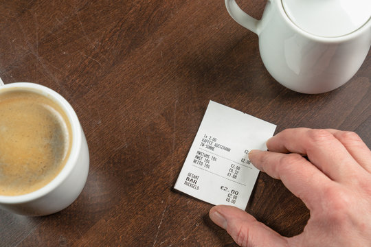 hand hold a receipt on a wooden table
