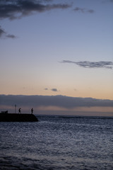 Man fishing during Sunset over pacific ocean silhouette, honolulu, HI, September 11, 2018