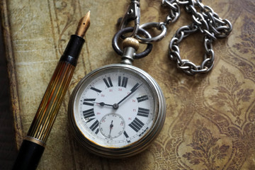 old pocket watch and chain on wooden background
