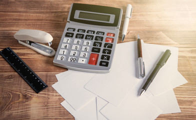 calculator and stationery on wooden background