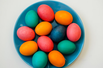 colored easter eggs on a blue plate on a white background