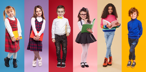 Positive schoolkids with books looking at camera