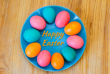 Fototapeta na wymiar Easter greeting card with colored eggs on a plate