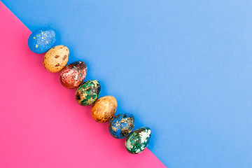 Multi-colored Easter eggs lie in a row.