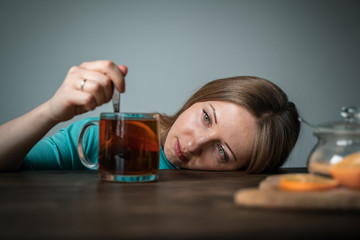 Sad girl with tea in a glass