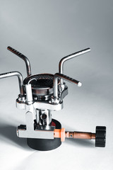 Cabeza de un hornillo de camping gas portátil sobre un fondo gris