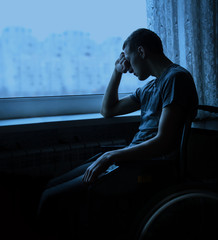 Disabled person in stroller by window