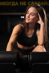 Fototapeta na wymiar Young girl on training apparatus in a gym portrait