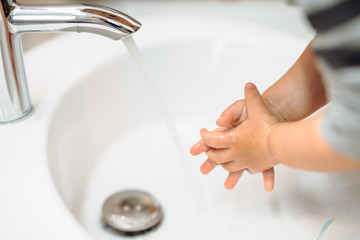Little baby toddler washing hands at home
